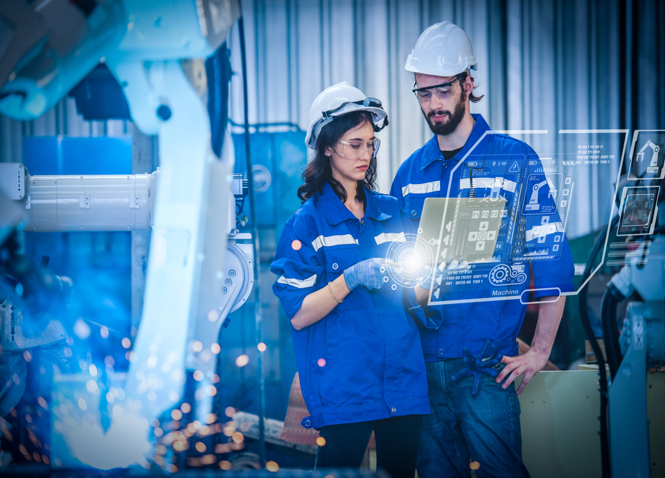 Engineers team mechanic using computer controller Robotic arm for welding steel in steel factory workshop. Industry robot programming software for automated manufacturing technology